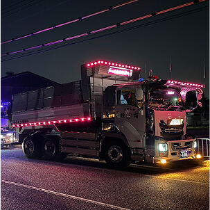 夜の道路を走行するLEDライトを装飾したダンプトラック
